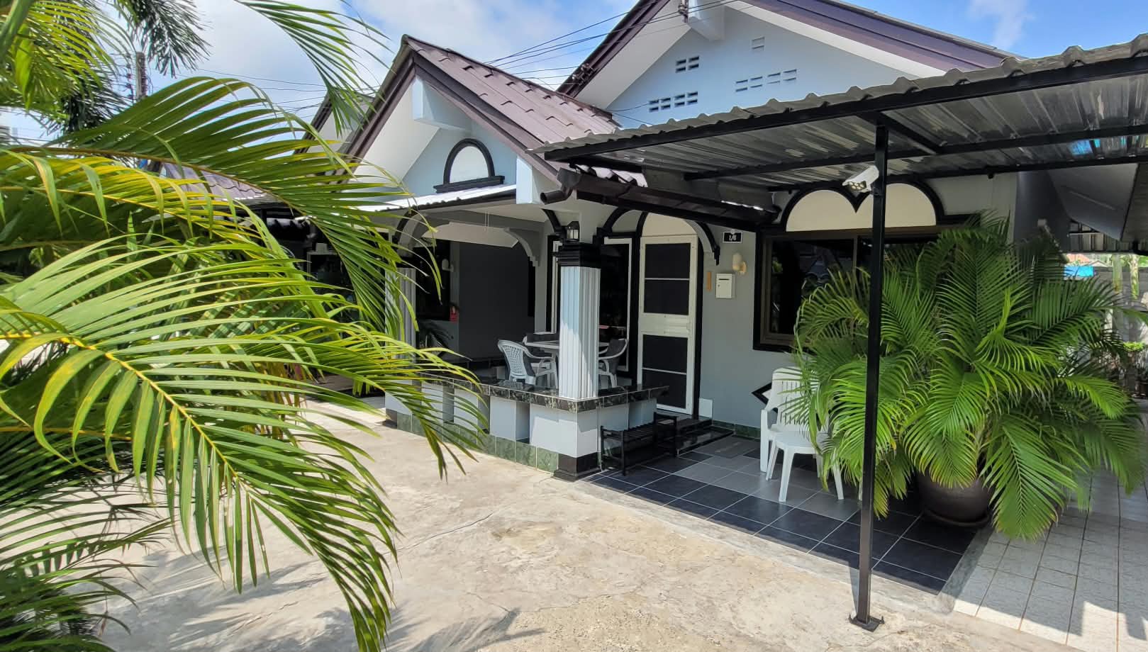 Covered porch of the villa among palms